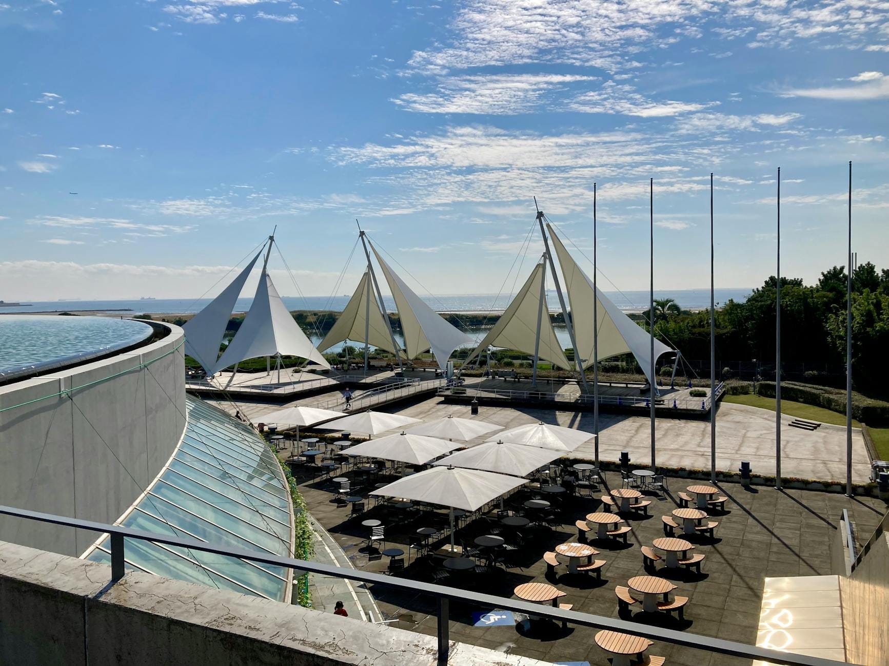 Nowoczesny taras z żaglowymi zadaszeniami w słoneczny dzień