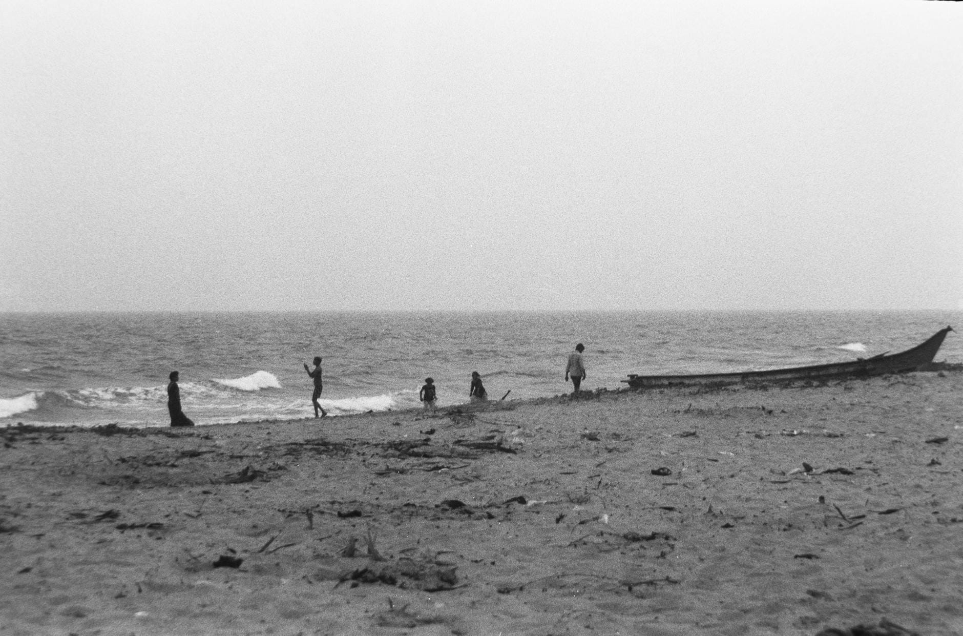 Jak karmić ryby podczas urlopu: 5 rozwiązań i ich pułapki Ludzie spacerujący po plaży w Andhra Pradesh w czarno-białej fotografii