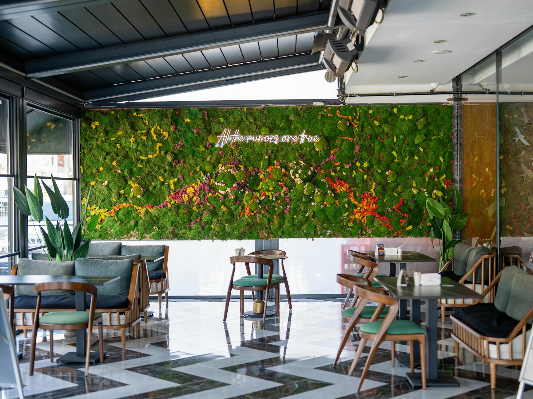 Przytulna kawiarnia z zieloną ścianą porośniętą mchem