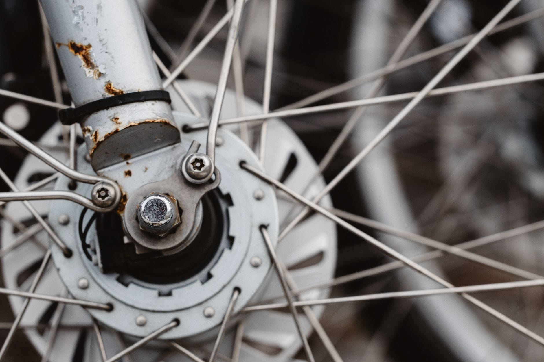 Zardzewiony piast rowerowy MTB z gęstą siecią metalowych szprych